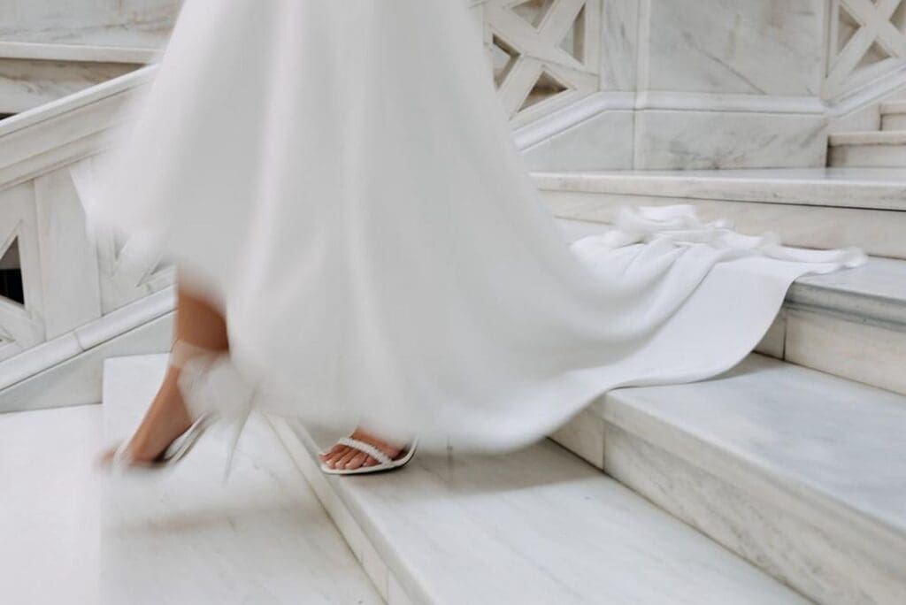 Photographer capturing bride walking down stairs in documentary wedding photography style